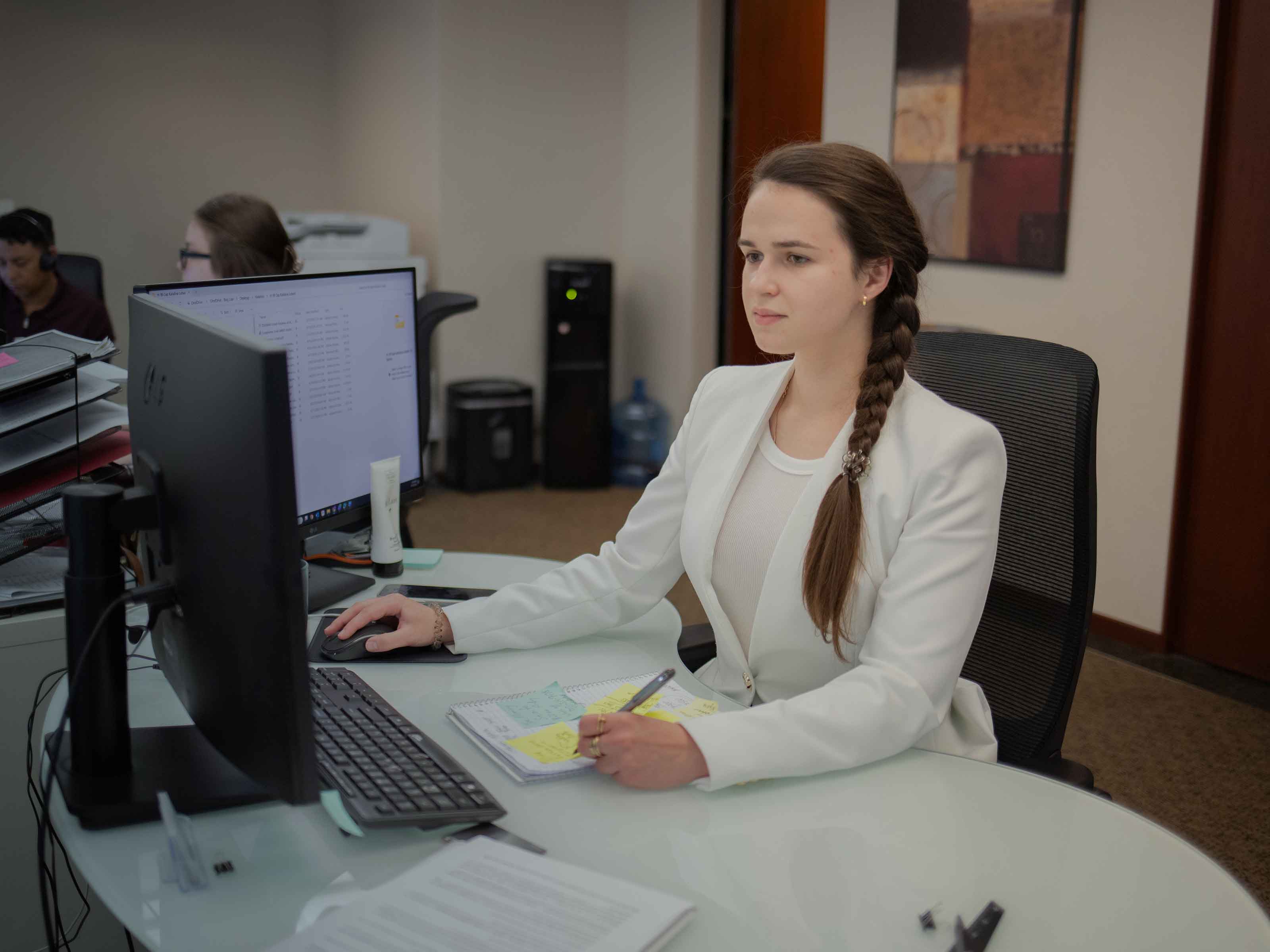 A BIRG Law legal assistant reviewing case notes at her computer in the open office