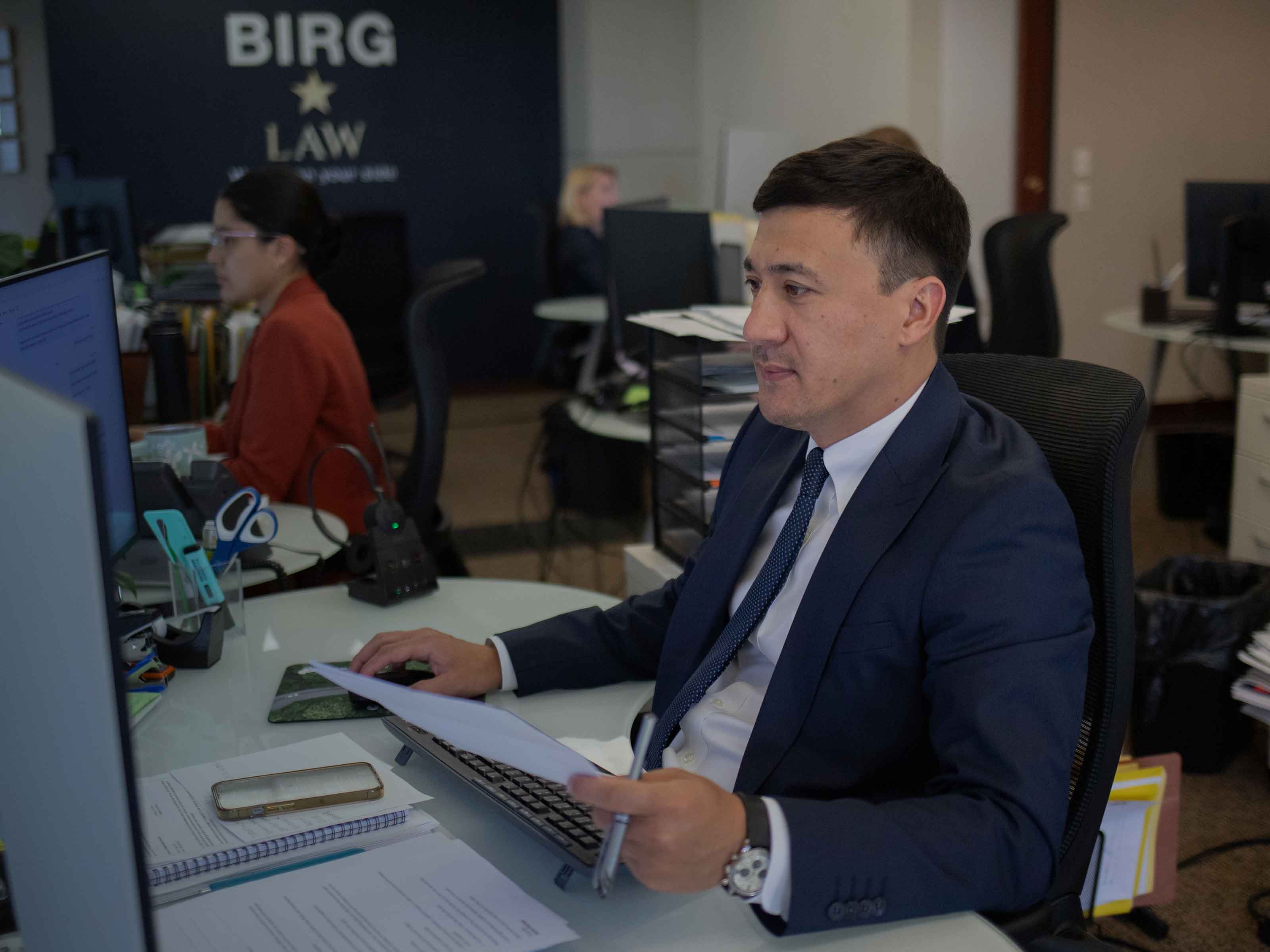 A BIRG Law case manager reviewing an immigration file at his desk