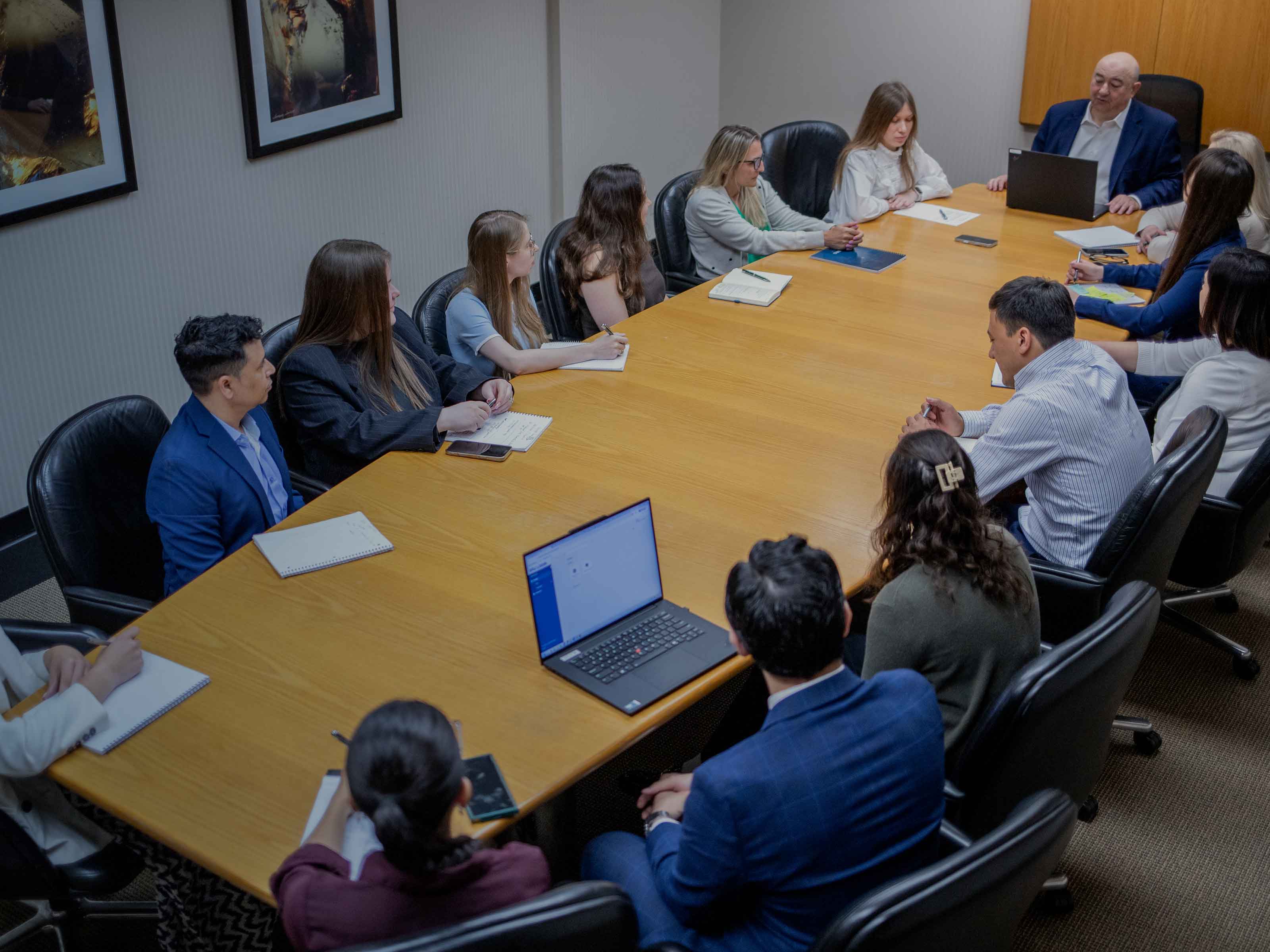 BIRG Law attorneys and legal staff gathered around the long conference table for a firm-wide case meeting