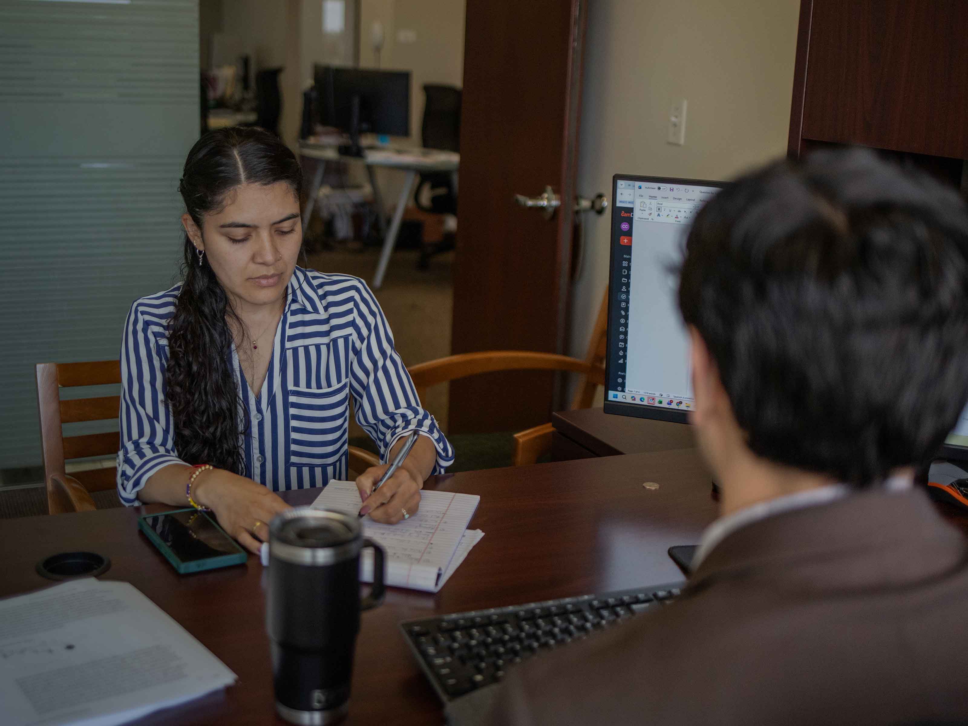 A BIRG Law team member taking notes during a client consultation in the office